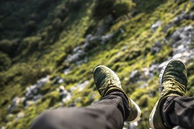 Low section of man wearing shoes on mountain