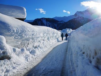 Tourists walking on snow covered mountain