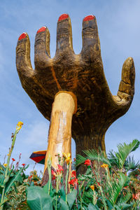 Low angle view of statues on field against sky