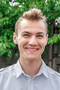 Smiling young man on a blurred green background