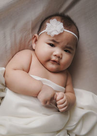 Cute baby girl lying on bed