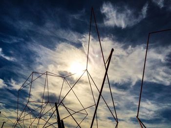 Low angle view of power lines against cloudy sky