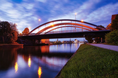 Bridge over river against sky at dusk