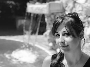 Portrait of smiling beautiful woman with fountain in background