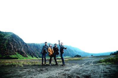 People standing on mountain against sky