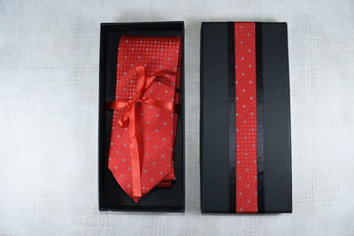 Close-up of red necktie in box on white table