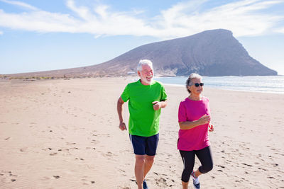 Senior couple jogging at beach