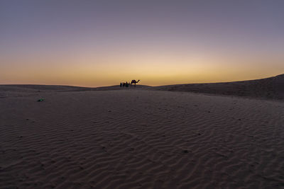 Scenic view of desert against sky during sunset