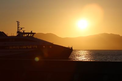 Silhouette boat in sea against sky during sunset