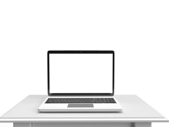 Low angle view of laptop on table against white background
