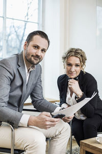 Portrait of confident business people with paperwork in office