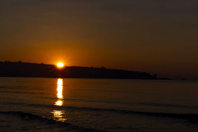 Scenic view of sea against romantic sky at sunset