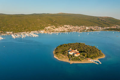 Aerial view of kosljun monastery with punat town in the background, krk island, croatia