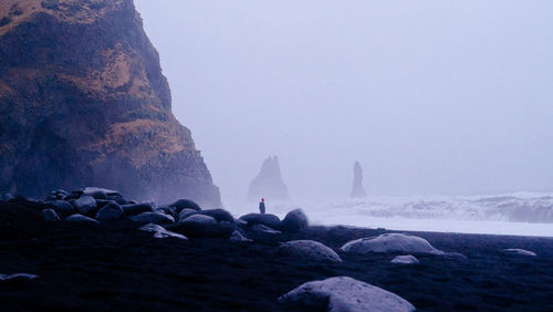 Rocks on beach against clear sky