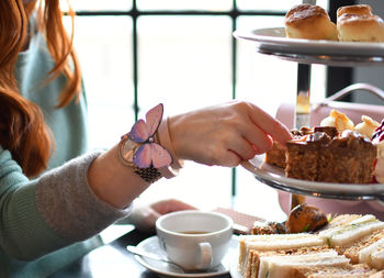 Midsection of woman coffee cup on table