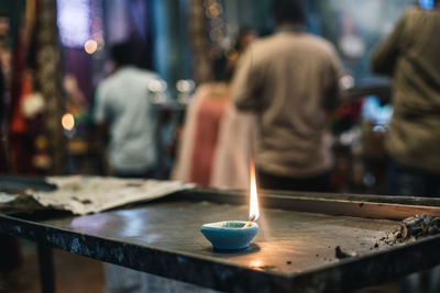 Close-up of lit candles on table