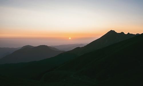 Scenic view of silhouette mountains against sky during sunset