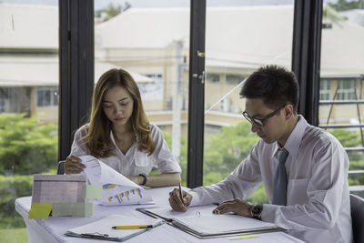 Young couple looking at camera while sitting on table