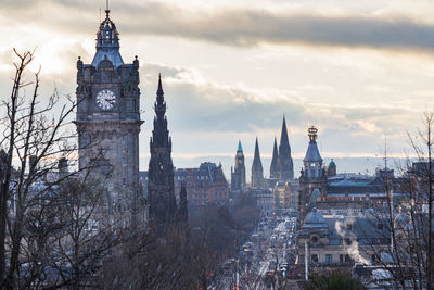 Panoramic view of buildings in city against cloudy sky