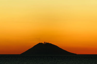 Scenic view of sea against orange sky