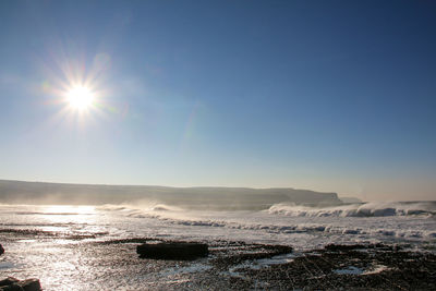 Scenic view of sea against clear sky on sunny day