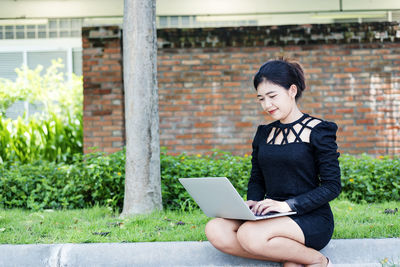 Beautiful businesswoman in black working on laptop . comfortable work or remote work concept.