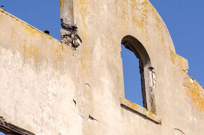 Low angle view of old building against clear blue sky