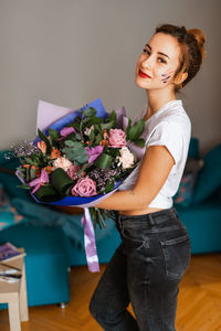 Portrait of young woman standing on table at home