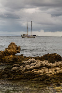 Sailboat on rock by sea against sky