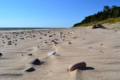 Scenic view of beach against clear blue sky