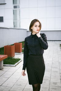 Portrait of beautiful young woman standing on tiled floor