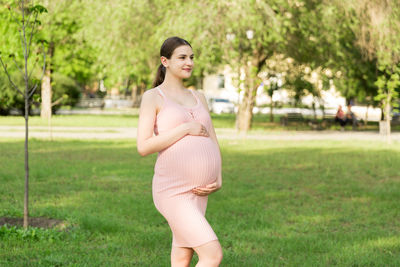 Pregnant woman standing in park