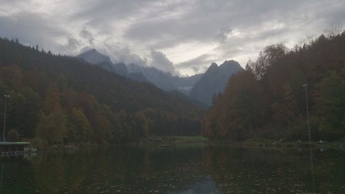 Scenic view of river and mountains against sky