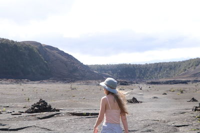 Rear view of woman hiking in hawaii against sky