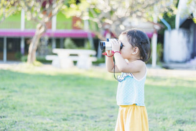 Young woman photographing with camera