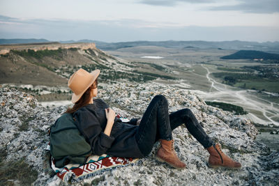 Full length of woman sitting on mountain