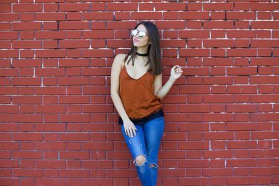 Woman standing against brick wall