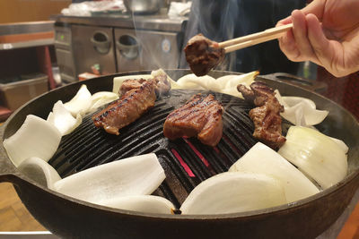 Close-up of person preparing food on barbecue grill