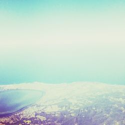 Aerial view of landscape and sea against clear sky