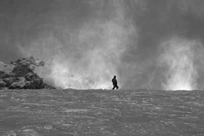 Man with arms outstretched in background