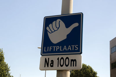 Low angle view of road sign against clear sky