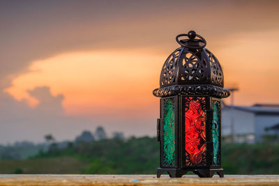 Close-up of old metal structure on field against sky during sunset