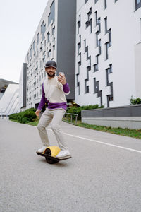 Full length of man skateboarding on road