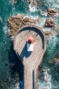 High angle view of woman standing by swimming pool