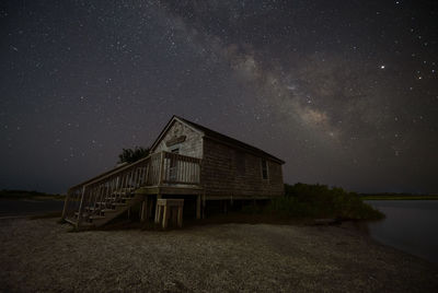Lifeguard hut on land against sky at night