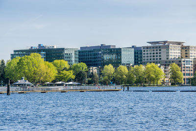 Scenic view of river by buildings against sky