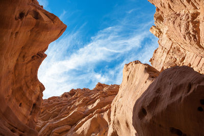 Low angle view of rock formations against cloudy sky