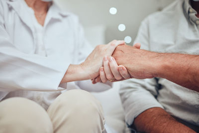 Midsection of couple holding hands