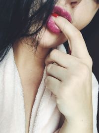 Midsection of seductive woman with finger in mouth