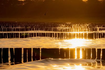 Scenic view of swimming pool by lake against sky during sunset